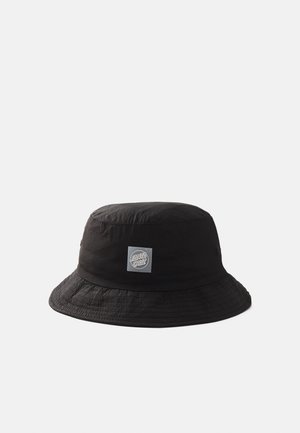 Black bucket hat made from lightweight fabric, featuring a square logo patch and a wide, textured brim.