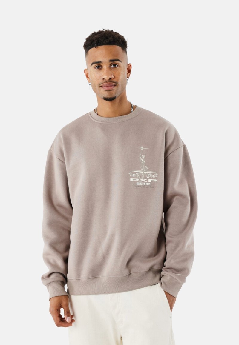 Sudadera marrón con cuello redondo, mangas largas y un estampado gráfico en el lado izquierdo del pecho que presenta texto y un emblema. Textura suave.