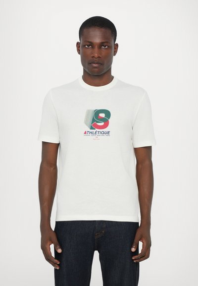 T-shirt blanc à manches courtes avec un imprimé graphique comportant des lettres et du texte multicolores en gras. Le tissu semble lisse avec une coupe décontractée.