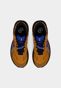 Πορτοκαλί και μπλε αθλητικά παπούτσια με επάνω μέρος από διχτυωτό ύφασμα, μαύρα κορδόνια και έντονη σόλα. Διαθέτουν υφή σχεδίασης και αναγνωρίσιμο λογότυπο.