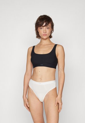 Black crop top with wide straps and a square neckline, paired with white high-waisted panties featuring a smooth texture and subtle branding.