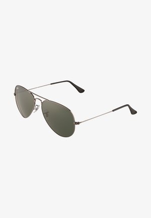 Occhiali da sole modello aviator con lenti verdi, montatura in metallo argentato e terminali neri. Presentano naselli regolabili e una classica forma a goccia.