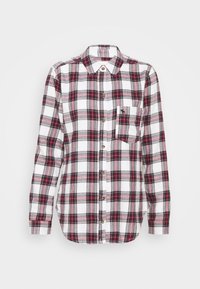 Camicia in flanella a quadri bianca, rossa e nera. Presenta un'apertura con bottoni, colletto e una tasca sul petto con un piccolo logo. Tessuto texture.