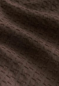 Brown textured fabric with a woven pattern, featuring raised squares and a smooth finish, suitable for upholstery or garments.