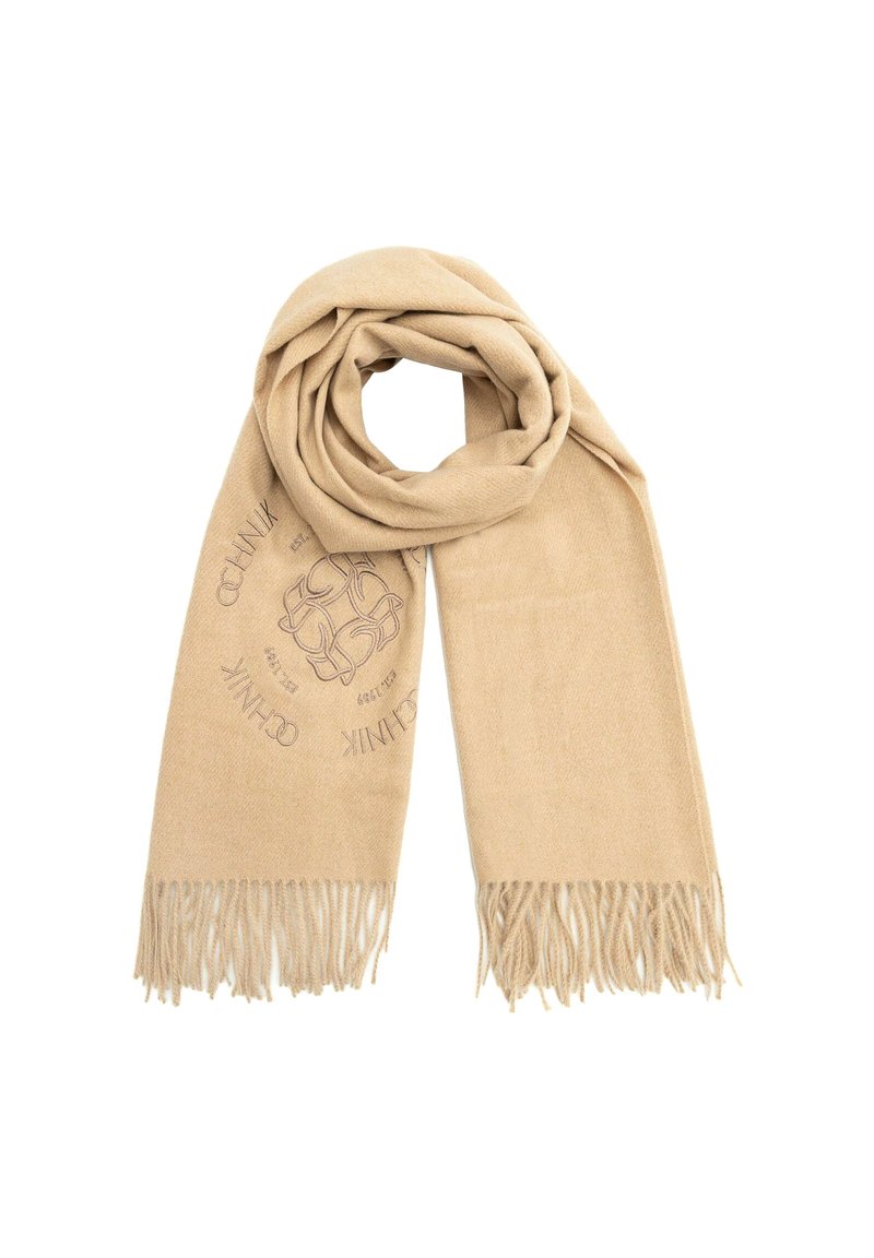 Beżowy szalik wykonany z miękkiego materiału, z tkaną strukturą i frędzlami na krawędziach. Ozdobny wzór w układzie okrągłym.