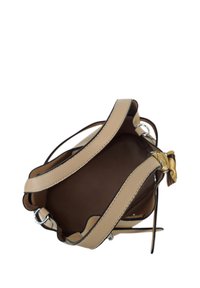 Beige leren handtas met een gestructureerd oppervlak, twee handvatten en een decoratieve strikaccent. Interieur toont een gladde bruine voering.