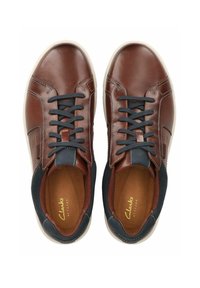 Bruna lädersneakers med blå detaljer, kontrasterande sömmar och mörkblå tygdetaljer runt kragen. Gummisula, snörning.