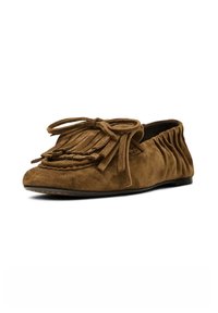 Brown suede moccasin flat with fringe detailing, braided trim, and a tied accent. Features a relaxed back design and a smooth sole.
