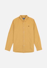 Chemise à manches longues jaune moutarde avec un col pointu, fermeture à boutons et un petit motif de flocon de neige brodé sur la poitrine.