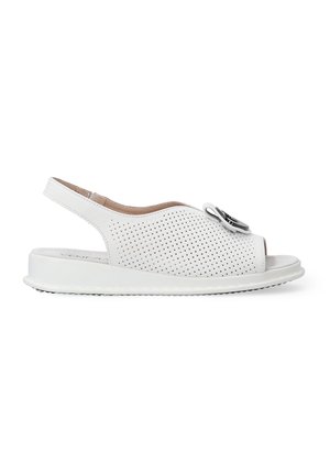 Hvide perforerede sandaler med åben tå og slingback-design. Har en flad sål og en dekorativ sort accent på forsiden.
