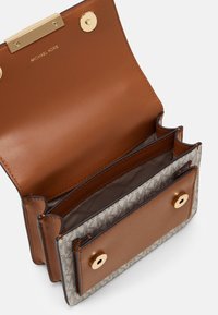 Brązowa skórzana torebka z złotymi dodatkami, wewnętrznymi przegrodami i beżowym wzorem na zewnątrz. Posiada zamek klamrowy i zapięcia magnetyczne.