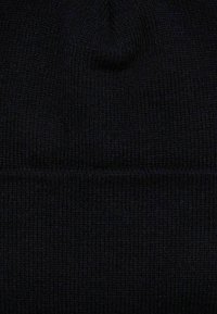 Sort strikket beanie-hat med en bl�ød tekstur, der har en tætsiddende pasform og et subtilt ribbet design, som forbedrer varme og komfort.