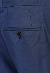 Blau strukturierter Stoff von maßgeschneiderten Hosen mit einer Gesäßtasche und einem schwarzen Knopf. Sauberes Design mit subtilen Details und glatter Verarbeitung.