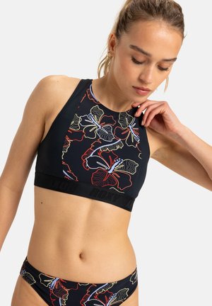 Zwarte zwemtop met kleurrijke bloemenprint, hoge halslijn en brede zwarte band met het merkteken. Bijpassende bikinibroekjes zichtbaar.