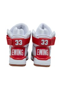 Sneakers înalte cu un superior din piele albă, accente roșii, guler căptușit, curea la toc și cu "33" și "EWING" brodate pe spate.
