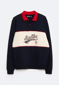 Tamsiai mėlynas polo marškinėlis su raudonu apykakle ir balta juostele. Savyje turi "BigStar" logotipą rašysena ir skaičių "79" pilkos spalvos. Pagamintas iš medvilnės, ilgomis rankovėmis.