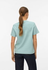 Lichtblauw shirt met korte mouwen en een ronde hals, gemaakt van gladde stof. Het shirt heeft een rechte zoom en een ontspannen pasvorm.