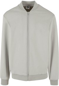 Ljusgrå bomberjacka gjord av mjukt tyg, med dragkedja framtill, ribbade muddar och rund halsringning. Enkel, minimalistisk design.
