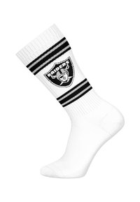 Weißer Sportsocken im Crew-Stil mit schwarzen und weißen Streifen, in der Mitte mit einem Raiders-Logo versehen. Das Material wirkt dehnbar und atmungsaktiv.