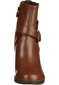 Bottine en cuir marron au design élégant, dotée d'une lanière ajustable et d'une boucle en laiton. Texture lisse et bout arrondi.
