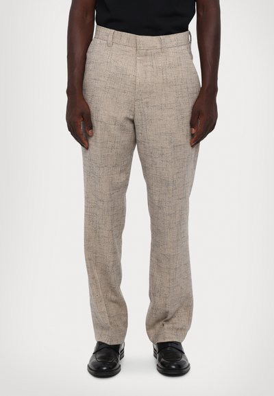 Beige textured trousers with a subtle pattern, straight leg design, belt loops, and side pockets, paired with black shoes.