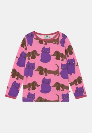 Chemise rose à manches longues avec un motif de chats violets et de teckels marron, dotée d'un col rond avec un bord rouge.