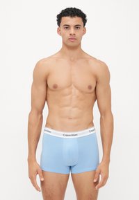 Lichtblauwe katoenen boxershorts met een witte tailleband waarop het "Calvin Klein" logo in het zwart staat. Glad textuur, aansluitend ontwerp.