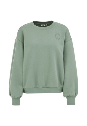 Zelena jopa iz mehke mešanice bombaža z okrolim izrezom, ohlapnega kroja ter širokimi manšetami in spodnjim robom z rebrastim vzorcem. Prisoten je subtilen vezen detajl.