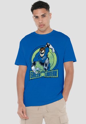 Young man wearing a blue Green Lantern t-shirt featuring the superhero in action against a green circular background.