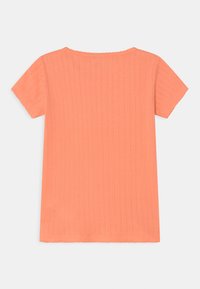 Top de manga curta em coral, com uma textura canelada, decote e bainha em estilo rendado, e riscas verticais ao longo do tecido.
