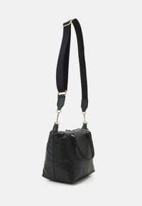 Schwarze Lederhandtasche mit strukturierter Form, ausgestattet mit einem abnehmbaren Schulterriemen aus schwarzem Stoff und goldenen Hardware-Akzenten.