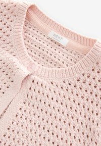 Cardigan lavorato a maglia di un leggero rosa pastello con una trama open weave, scollatura rotonda e chiusura con un singolo bottone sul davanti. Etichetta visibile all'interno.