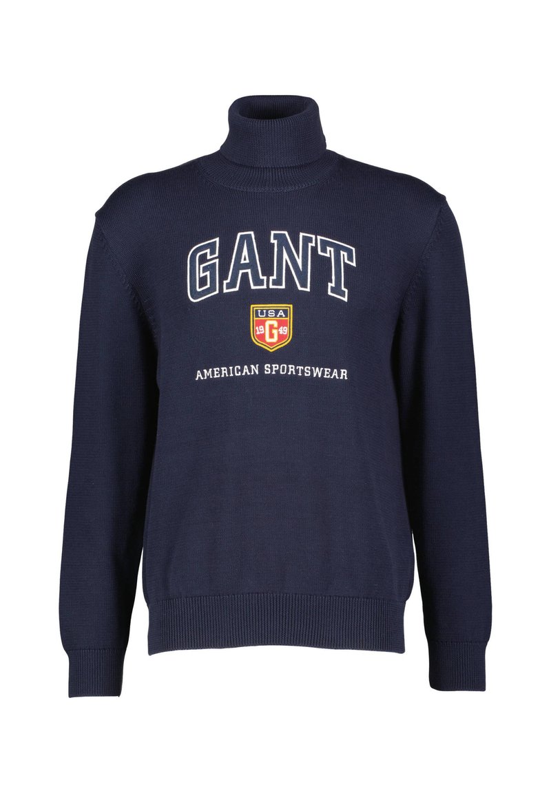 Navyblauer Rollkragenpullover aus strukturiertem Material mit großem weißem "GANT"-Logo und Wappensymbol auf der Brust.
