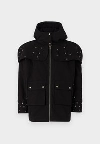 Chaqueta negra con capucha, con hombros y mangas adornados con tachuelas. Presenta un cierre delantero con cremallera y dos grandes bolsillos frontales. Textura de tela suave.