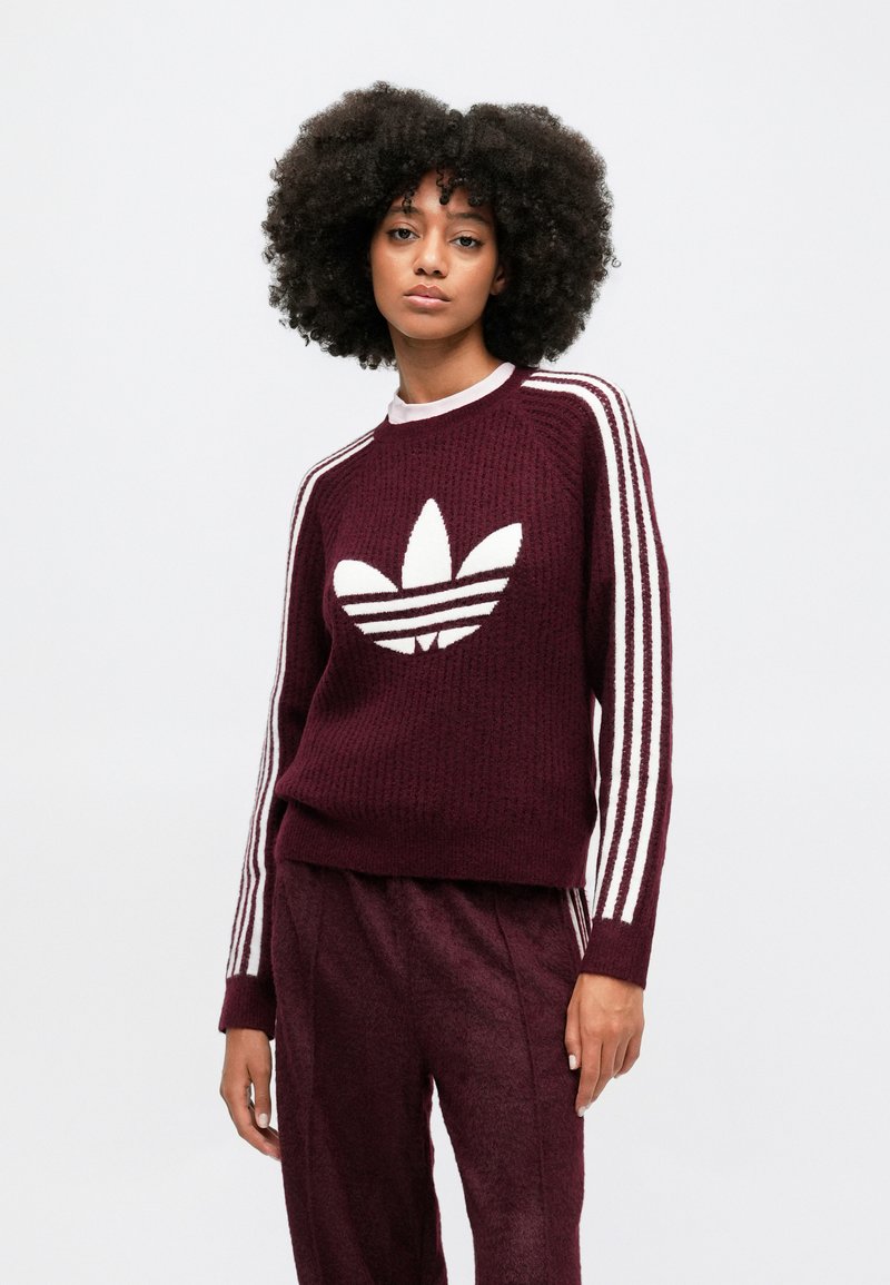 Burgunderfarbener Strickpullover mit weißem Streifencrew-Neck und gerippten Bündchen, mit einem großen weißen Trefoil-Logo auf der Vorderseite.