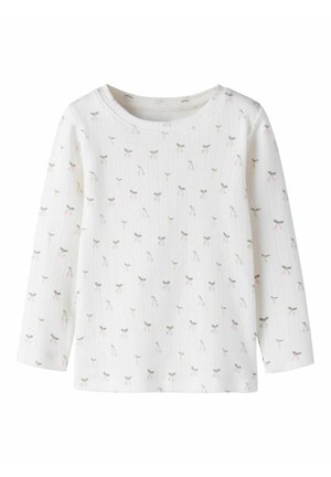 Chemise blanche à manches longues en tissu côtelé avec un petit nœud gris et rose ainsi qu'un motif de fleurs partout.