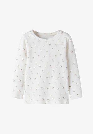 Camisa blanca de manga larga con textura de canalé y pequeño patrón de lazos grises y rosas con flores en toda la prenda.