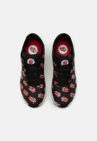 Juodi sportbačiai su pakartotiniu raudonų ir baltų lūpų raštu, su juodais raišteliais ir tekstūruota raudona vidpadžiu, ant kulno esantis logotipas.