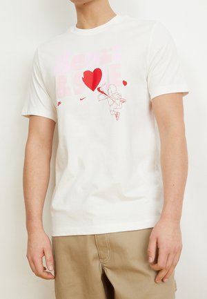 Biała bawełniana koszulka z kolorowym napisem "Heart & Soul" oraz postacią uśmiechniętego anioła trzymającego serce. Krótkie rękawy i okrągły dekolt.