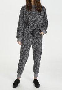 Grå leopardmønstret sweatshirt og joggers lavet af blødt stof. Sættet har ribstrikkede manchetter og en elastisk talje med snøre.