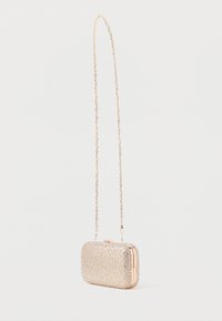 Kristālu rotājumiem bagātināta rokassomiņa ar taisnstūra formu, zelta ķēdes siksniņu un metalizētu aizdari. Spīguļa, teksturēta virsma ar caurspīdīgiem akcentiem.