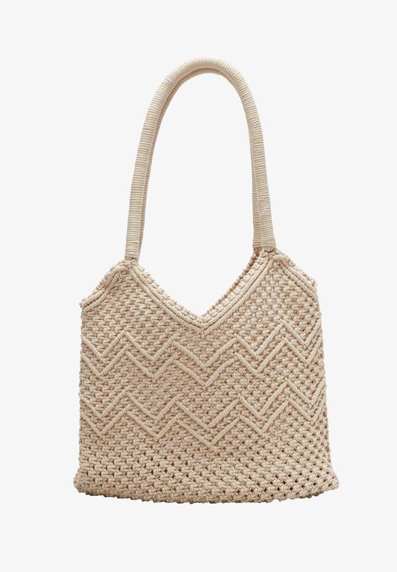 Sac fourre-tout tissé beige avec motif en zigzag et une seule poignée épaisse et arrondie sur fond blanc.