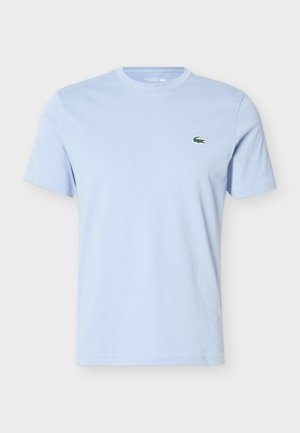 Light blue short-sleeve cotton T-shirt with crew neck and small green crocodile logo on the left chest.