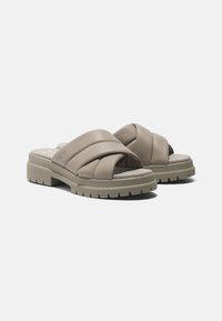 Sandali in pelle taupe chiaro con fascia incrociata, suola spessa e battistrada testurizzato per stabilità. Fodera morbida per comfort.