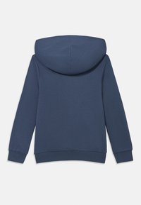 Felpa con cappuccio blu navy realizzata in tessuto morbido, con tasca a marsupio, polsini a costine e cappuccio arrotondato dalla superficie liscia.