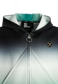 Chaqueta con capucha con un degradado suave de negro a gris. Presenta un zipper con tirador de metal, costuras contrastantes y un pequeño parche de logo.