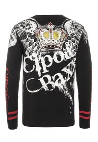 Schwarzes Langarmshirt mit weißen Schriftzügen, Flügelgrafiken und einem mit Juwelen besetzten Kronendesign auf der Rückseite. Rote Akzente an den Ärmeln.