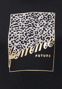 Svart t-skjorte med en leopardmønstret rektangel og gulltekst som sier "femme FUTURE" med en omrissgrense.