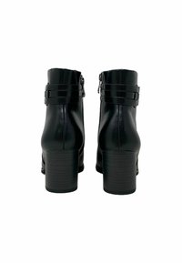 Stivali neri in pelle alla caviglia con finitura liscia, dotati di tacco a blocco e due fasce decorative sulla caviglia. Chiusura con cerniera sul retro.