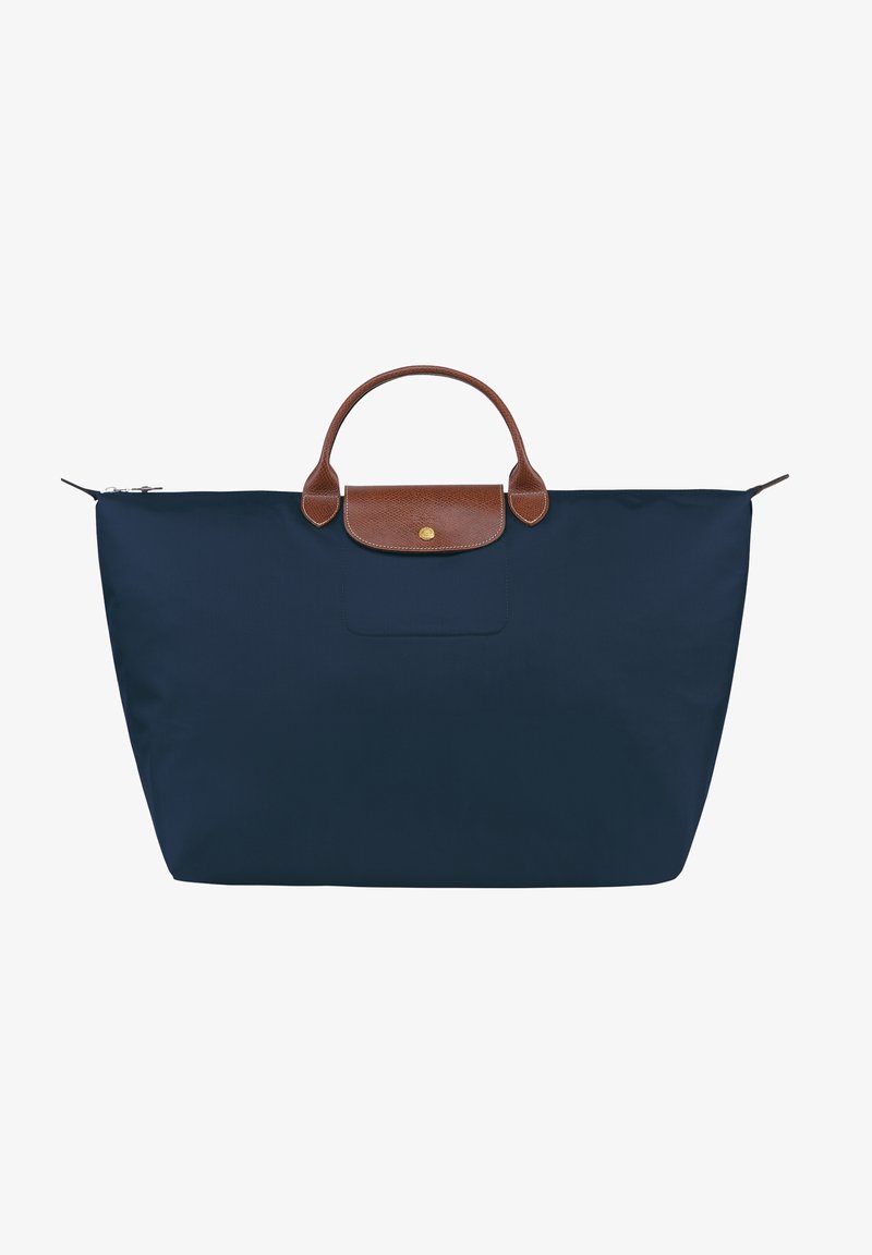 Navy blue nylon tote bag with a brown leather handle and top closure. Features a front pocket and minimalistic design. Lightweight and spacious.